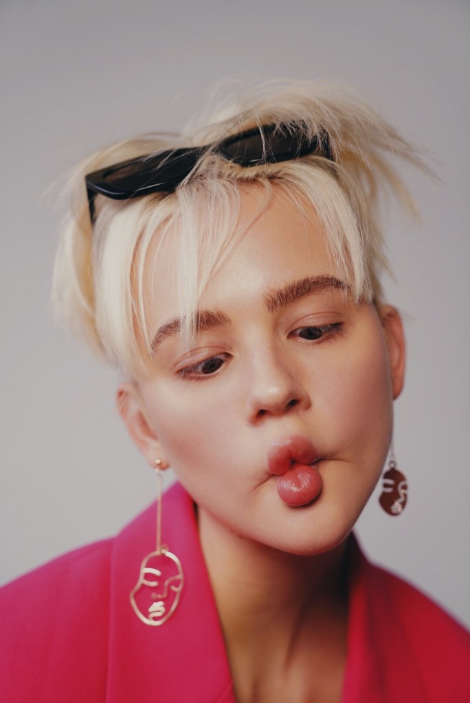 Model Chelsey Boll pulls a funny facial expression for a fashionable self portrait. Her lips are squished together and she is cross eyed.